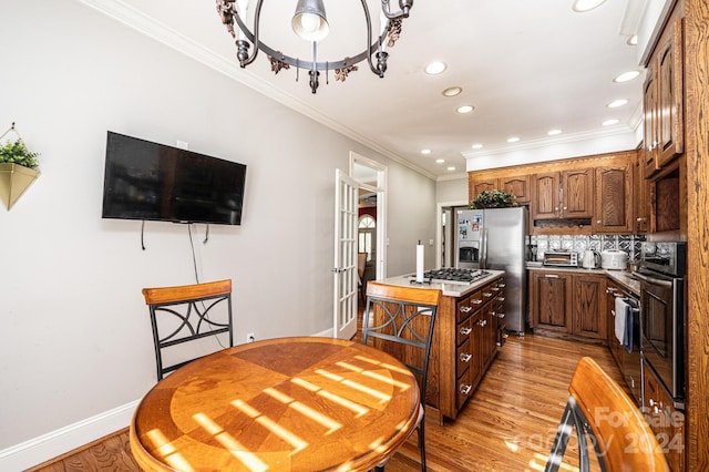 kitchen with backsplash, oven, stainless steel refrigerator with ice dispenser, and light wood-type flooring