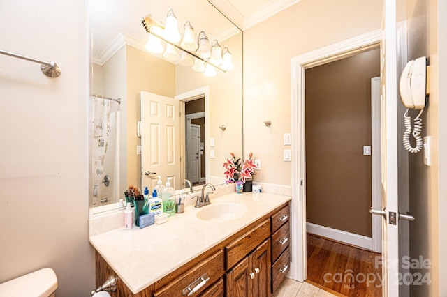 bathroom with toilet, hardwood / wood-style floors, vanity, and ornamental molding