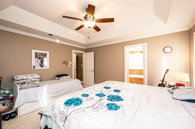 bedroom with ensuite bathroom, crown molding, ceiling fan, a tray ceiling, and carpet floors