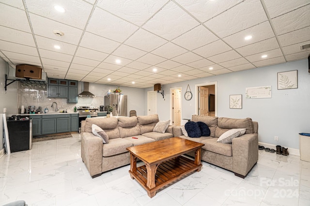 living room with a drop ceiling and sink