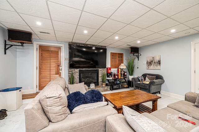 living room with a fireplace and a paneled ceiling