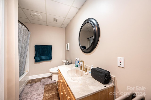 full bathroom with a paneled ceiling, vanity, shower / bath combo, tile patterned flooring, and toilet