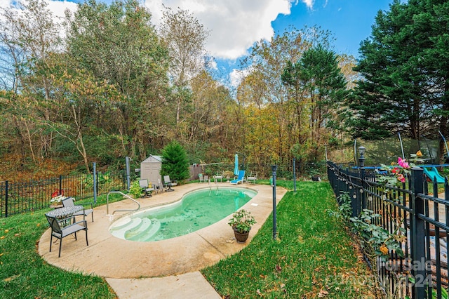 view of pool with a patio, a trampoline, a storage shed, and a lawn