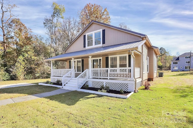 view of front of property featuring covered porch, cooling unit, and a front yard