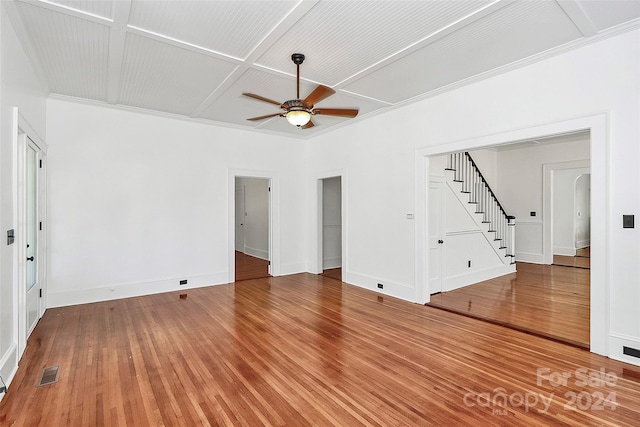 unfurnished living room with hardwood / wood-style floors, ornamental molding, ceiling fan, and coffered ceiling