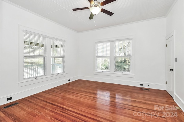 unfurnished room featuring ceiling fan, a healthy amount of sunlight, wood-type flooring, and ornamental molding