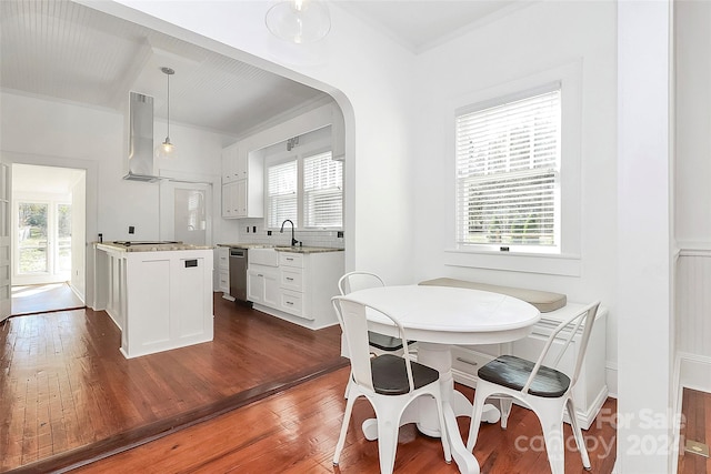 dining area featuring a healthy amount of sunlight, dark hardwood / wood-style floors, and ornamental molding