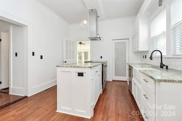 kitchen featuring white cabinetry, light stone countertops, light hardwood / wood-style flooring, decorative light fixtures, and appliances with stainless steel finishes