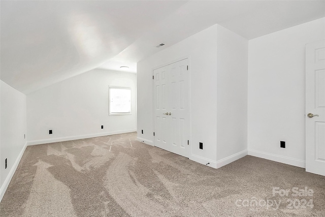 bonus room with carpet flooring and vaulted ceiling