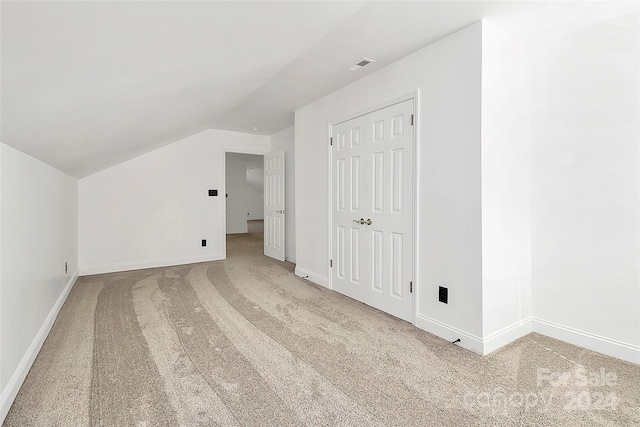 additional living space featuring carpet flooring and vaulted ceiling