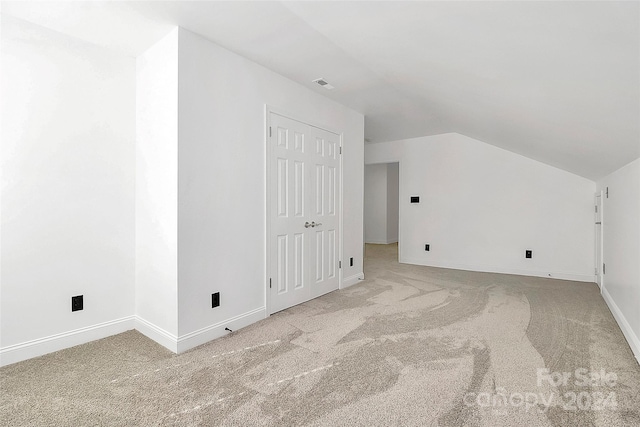 additional living space featuring carpet flooring and vaulted ceiling