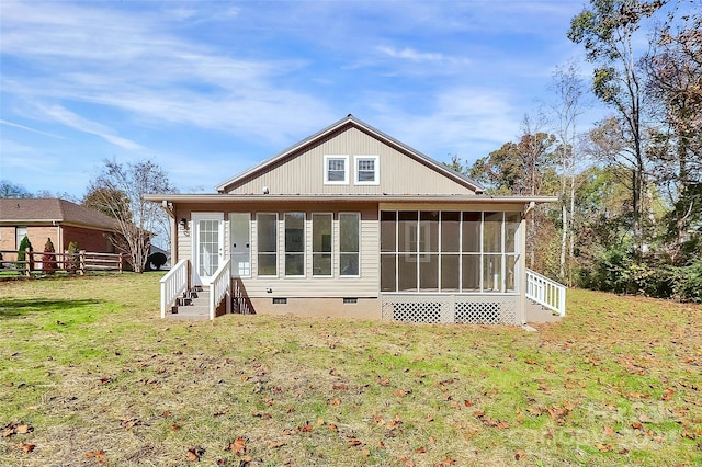 rear view of property featuring a sunroom and a lawn