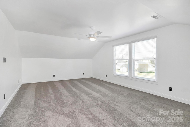 additional living space featuring lofted ceiling, carpet, baseboards, visible vents, and a ceiling fan