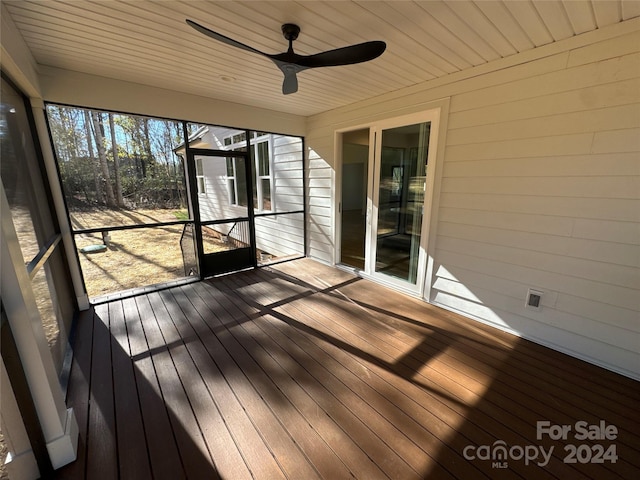 unfurnished sunroom with ceiling fan