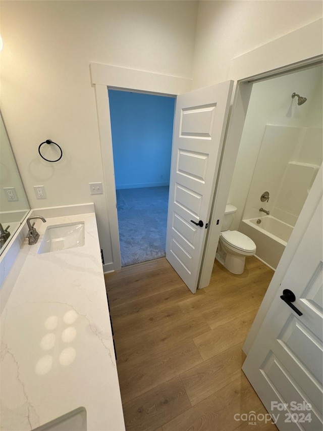 full bathroom featuring bathing tub / shower combination, toilet, vanity, and hardwood / wood-style flooring