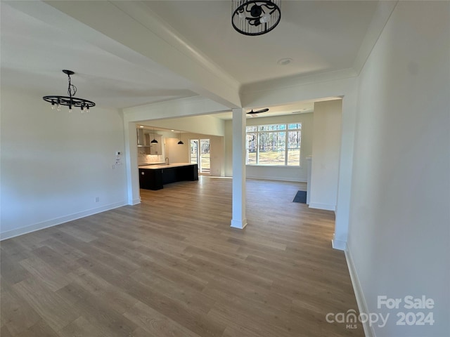 unfurnished living room with hardwood / wood-style flooring and an inviting chandelier