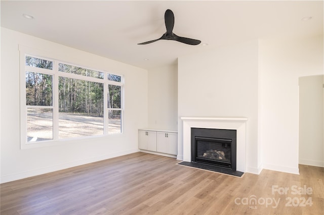 unfurnished living room with ceiling fan and light hardwood / wood-style floors