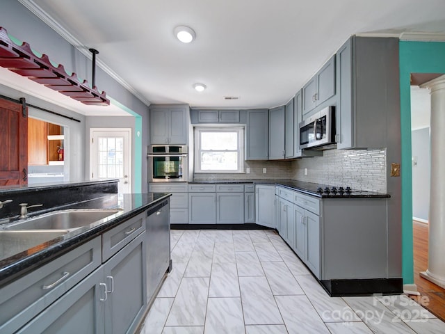 kitchen with gray cabinetry, crown molding, a wealth of natural light, and appliances with stainless steel finishes