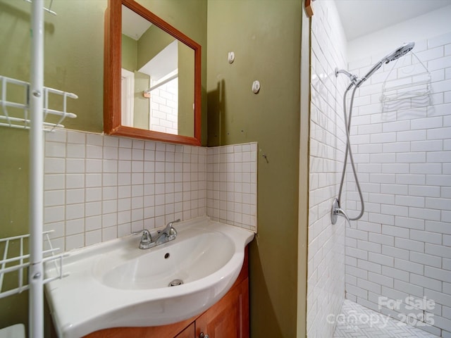 bathroom featuring tasteful backsplash, vanity, and tiled shower