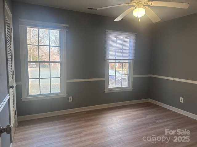 spare room with plenty of natural light, ceiling fan, and light wood-type flooring