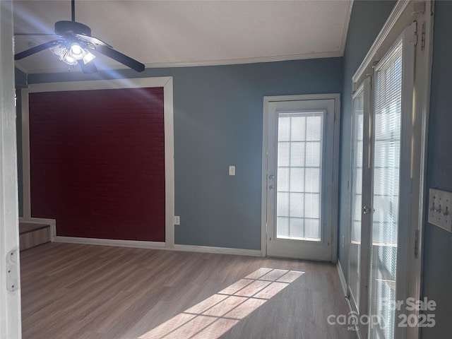 interior space with ornamental molding, plenty of natural light, and light hardwood / wood-style floors