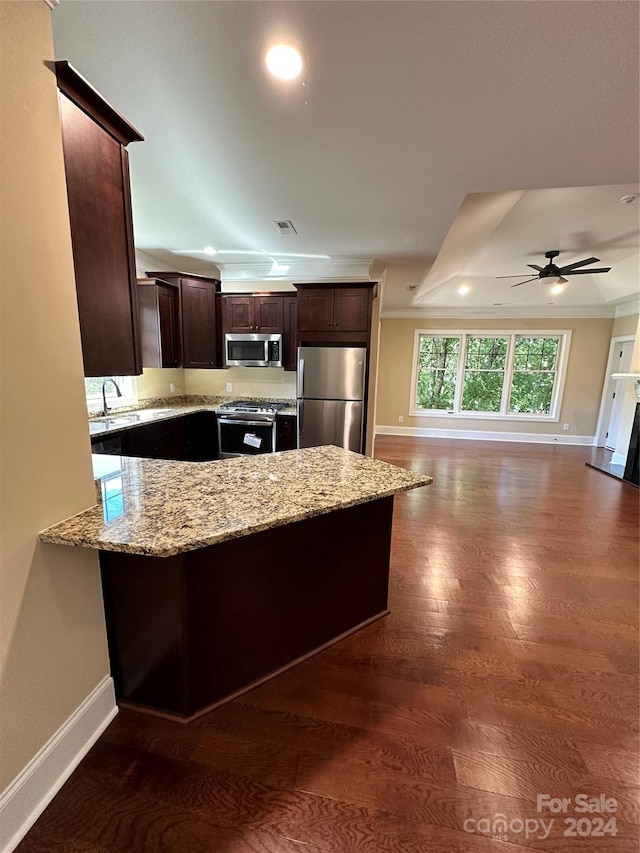 kitchen with light stone counters, dark hardwood / wood-style flooring, ceiling fan, and stainless steel appliances