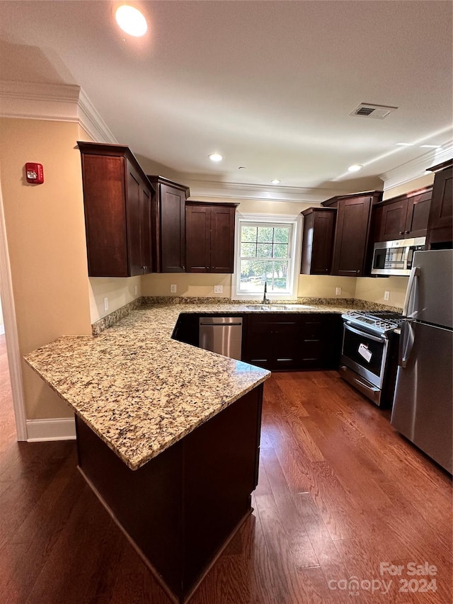 kitchen featuring kitchen peninsula, stainless steel appliances, light stone countertops, and dark wood-type flooring