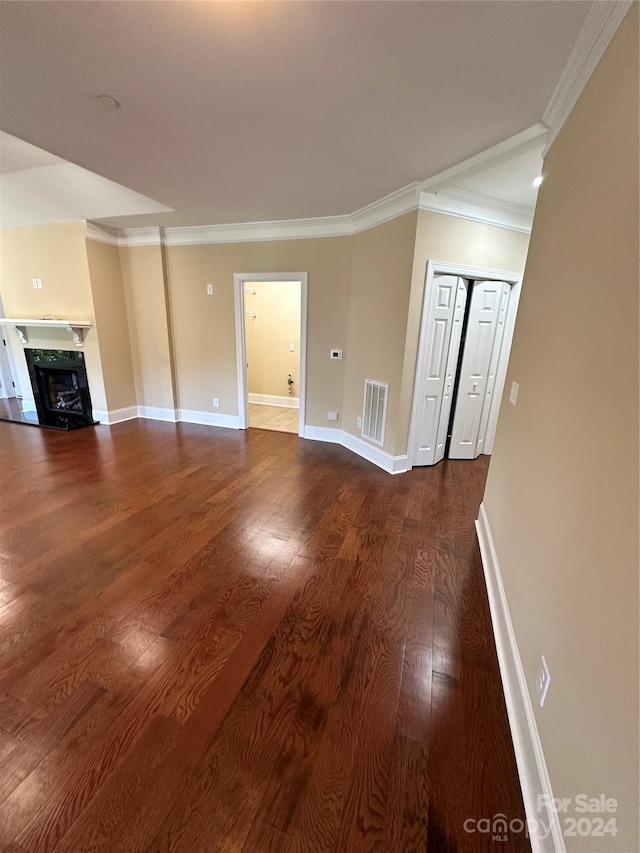 unfurnished living room with hardwood / wood-style floors and ornamental molding