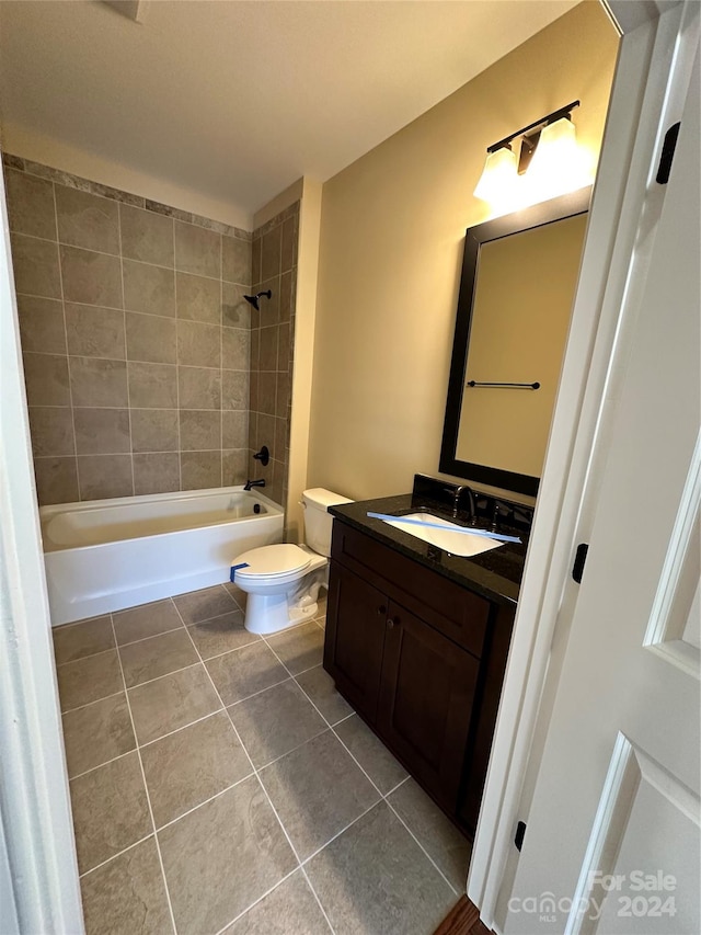 full bathroom featuring toilet, vanity, tile patterned floors, and tiled shower / bath