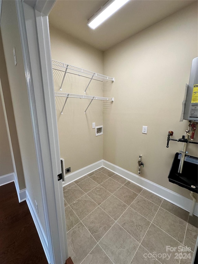 clothes washing area featuring water heater, tile patterned flooring, washer hookup, and hookup for a gas dryer