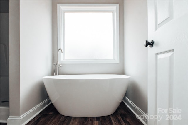 bathroom featuring a tub to relax in and wood-type flooring