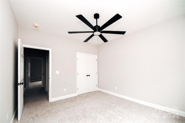 unfurnished bedroom with ceiling fan, light colored carpet, and a closet