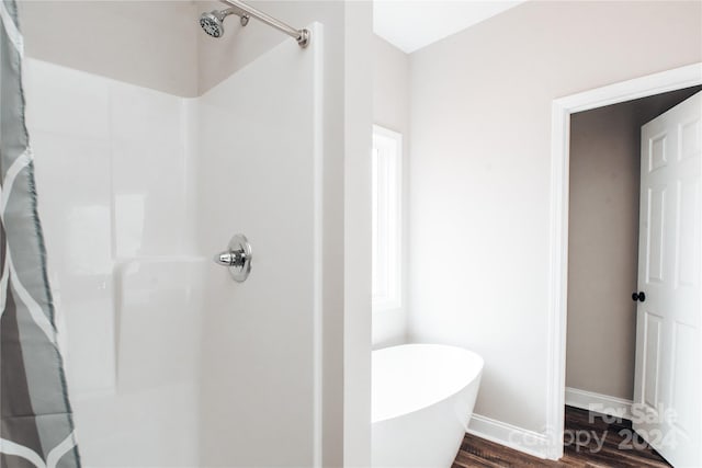 bathroom featuring wood-type flooring and independent shower and bath