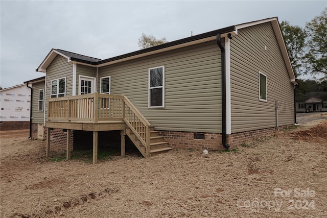 rear view of property featuring a wooden deck