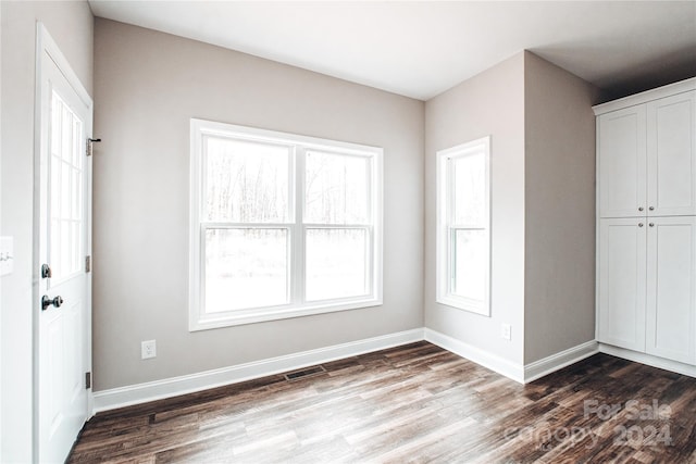 unfurnished room with dark hardwood / wood-style flooring