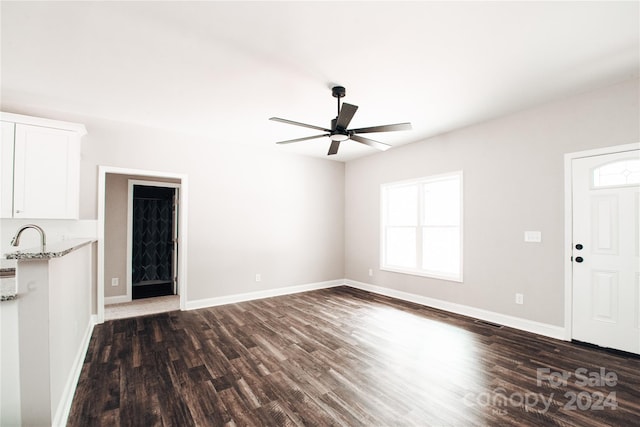 unfurnished living room featuring ceiling fan and dark hardwood / wood-style flooring