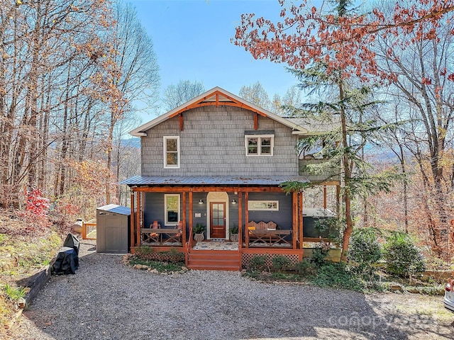 view of front of home featuring covered porch and a storage shed