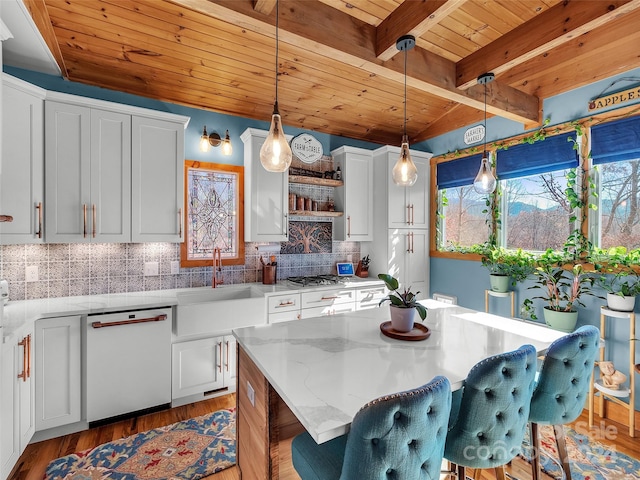 kitchen with dishwasher, a center island, and white cabinets