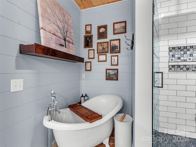 bathroom featuring a bathtub and tile walls