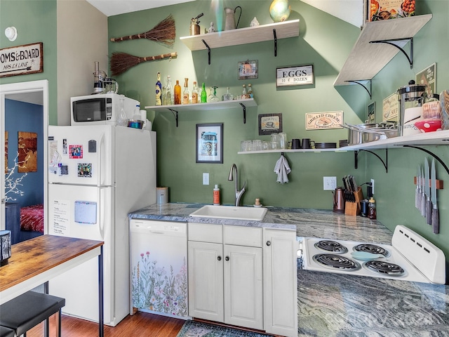 kitchen with sink, white cabinets, wood-type flooring, and white appliances