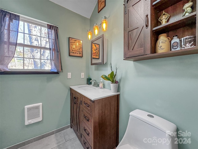 bathroom with heating unit, tile patterned flooring, vanity, and toilet