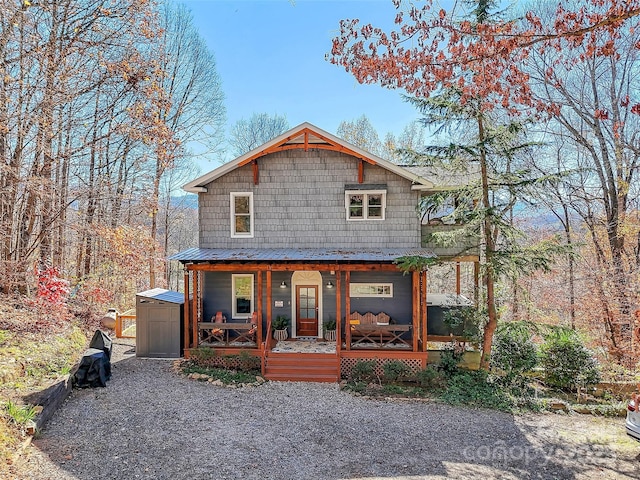 view of front of home featuring a porch and a shed