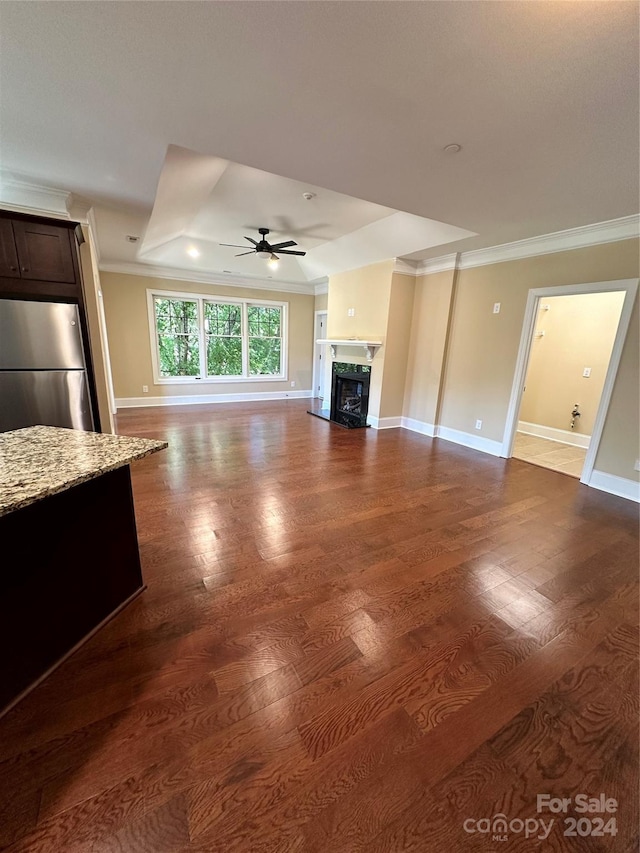 unfurnished living room with hardwood / wood-style flooring, ceiling fan, and ornamental molding