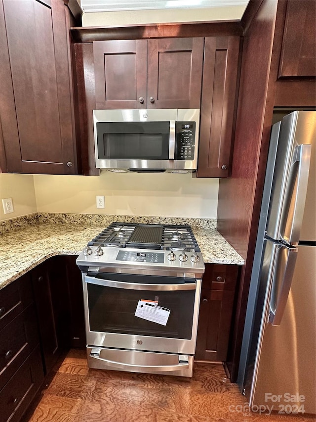 kitchen featuring light stone countertops, appliances with stainless steel finishes, and dark brown cabinetry