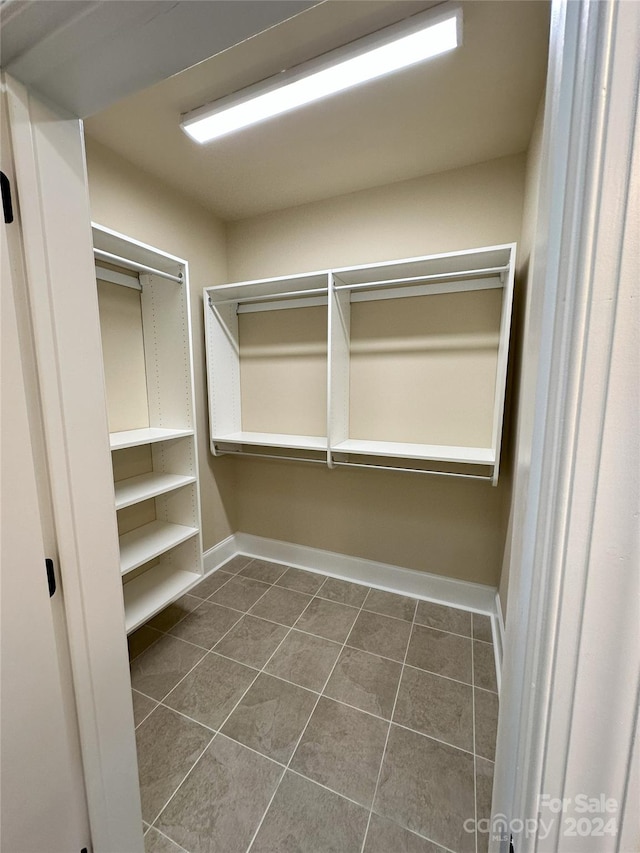 spacious closet featuring dark tile patterned floors