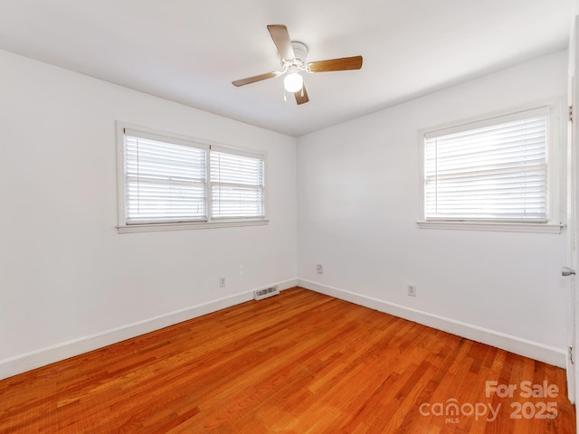 empty room with hardwood / wood-style flooring and ceiling fan