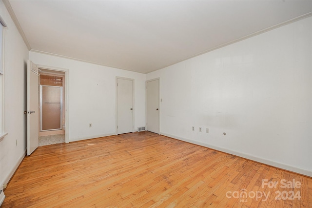 unfurnished bedroom featuring light hardwood / wood-style flooring and crown molding