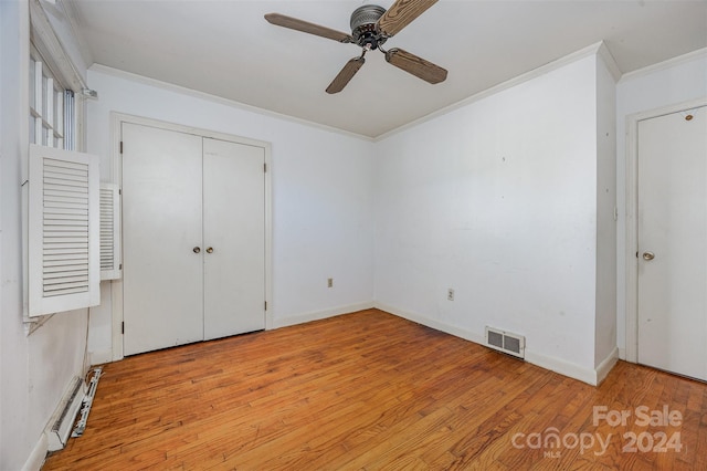 unfurnished bedroom featuring a closet, ceiling fan, crown molding, and light hardwood / wood-style floors