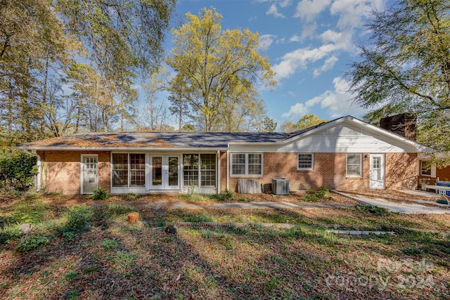 rear view of house featuring cooling unit and french doors