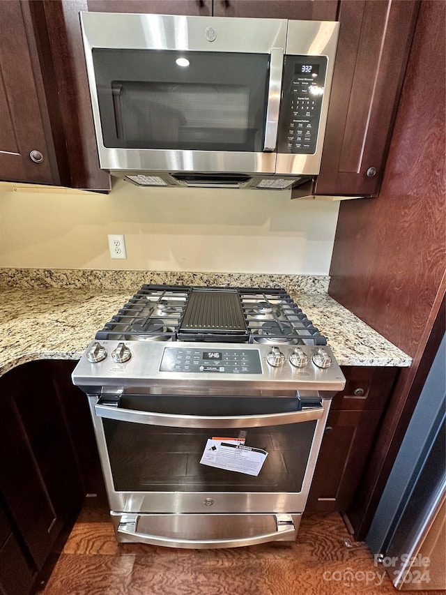 room details featuring light stone countertops, appliances with stainless steel finishes, and dark brown cabinetry